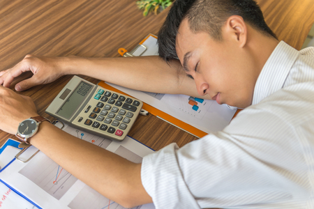 Young Asian employee feel tired and frustrated with his jobの写真素材