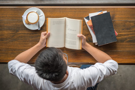 High angle view of young student reading books at the cafe
