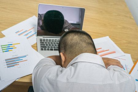 Tired and stressful man overloaded with financial problems at work