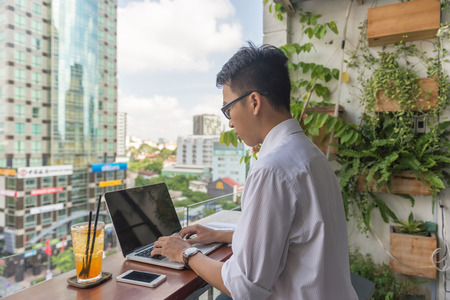 Asian Young man working on laptop outdoor the business officeの写真素材