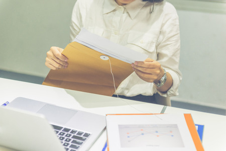 Businesswoman hand open the envelope in the officeの写真素材