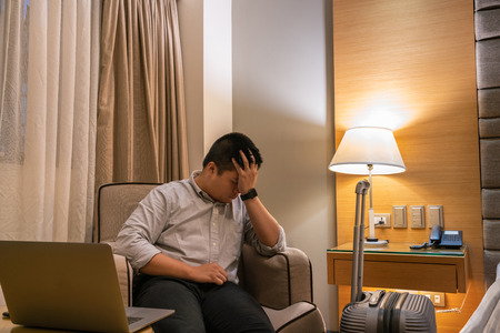 Asian businessman feels tired and frustrated in the business tripの写真素材