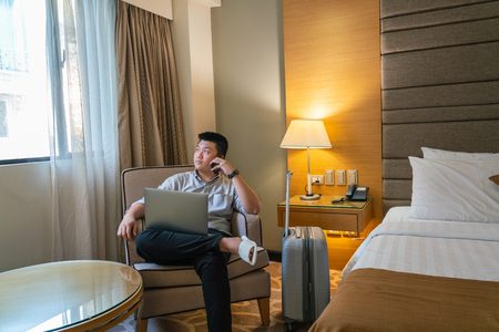 Asian businessman talk on phone in the hotel roomの写真素材