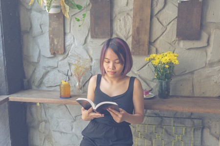 Young Asian woman reading books at weekendの写真素材