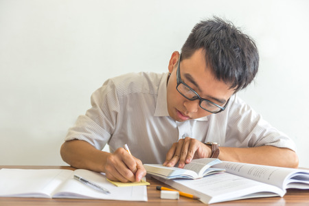 Asian student doing homework at the libraryの写真素材