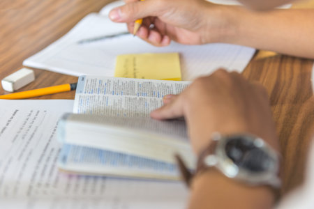 Side view of student hands writing into sticky notes
