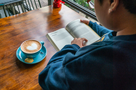 Rear view of young woman reading bookの写真素材