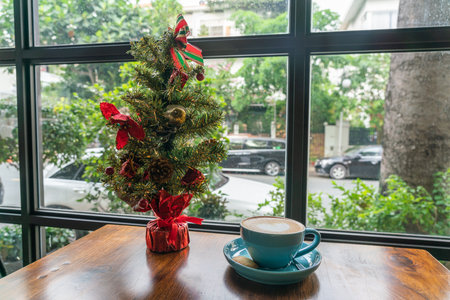 Cup of Cappuccino and Christmas decoration next to the window