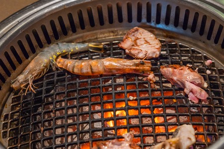 Fried shrimps seafood and steak by fire and BBQ flamesの写真素材