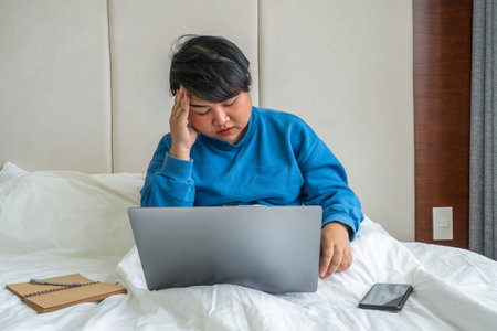 Asian woman feel headache and tired on bed