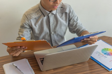 Young businessman reading financial report at workplaceの写真素材
