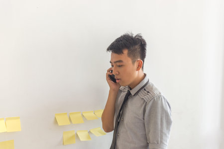 Asian businessman talking on phone in the office
