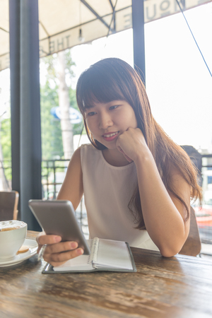 Asian girl surfing the Internet on smartphoneの写真素材