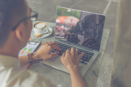Rear view of Asian businessman working on laptopの写真素材