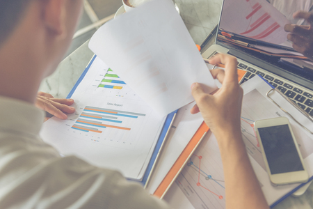 Rear view of Asian office employee checking financial documentsの写真素材