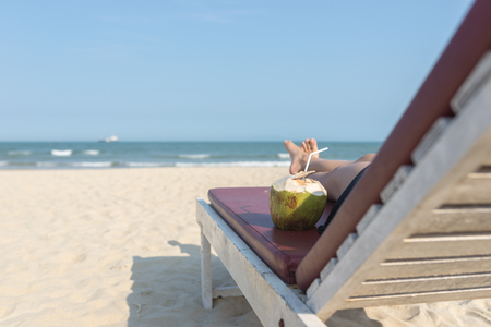 Relaxing with fresh coconut on beach chair in summer vacationの写真素材