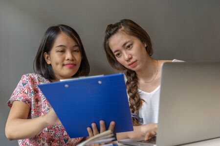 Young Asian women discuss about finance documentsの写真素材