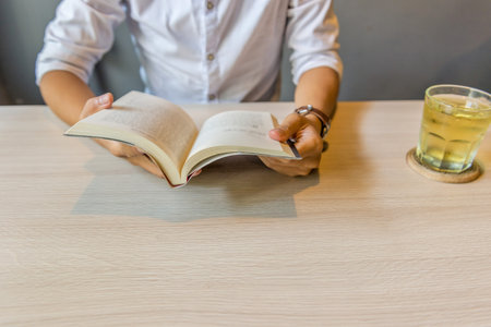 Close up of man wearing white shirt reading book