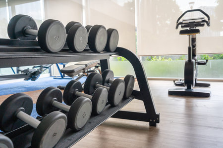Fitness machine and dumbbells on shelf in gym room