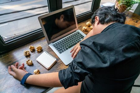 High angle view of freelancer fall asleep at unorganized workplaceの写真素材