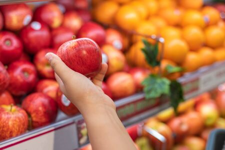 Human hand picking apple at fruit storeの写真素材