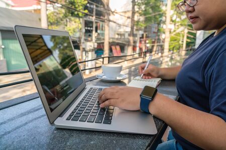 Young Asian freelancer working on laptop outdoorの写真素材