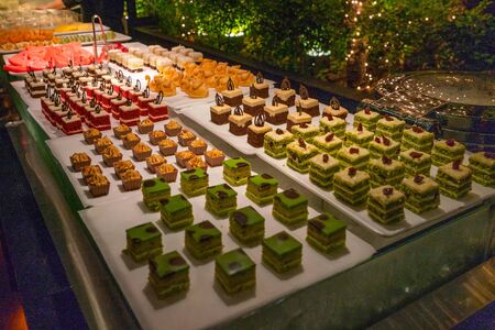 Well-decorated pieces of cake and pastry for a partyの写真素材