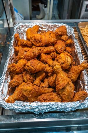Vertical photo of pile of fried chicken drumsticks at marketの写真素材