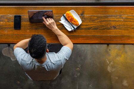 Top view of Asian millennial using tablet while having breakfastの写真素材