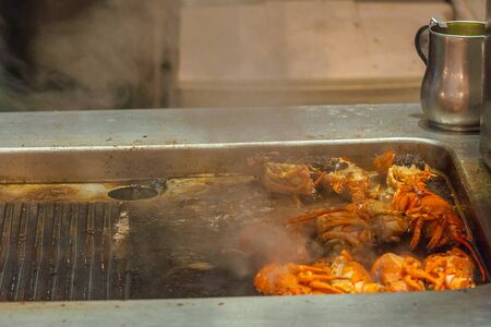 Grilled lobsters on electric stove with smoke inside restaurants kitchenの写真素材