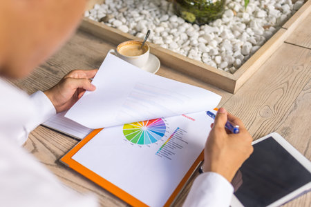 Rear view of businessman analyzing pie chart statistics data document
