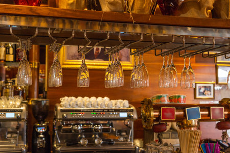 Clean and tidy wine glasses hanging at vintage bar counter