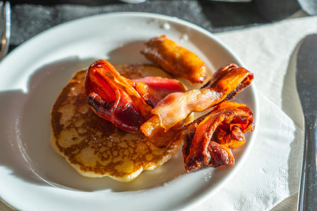 Delicious pancake and roasted bacon on white dish for breakfast