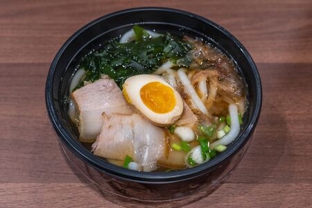 Bowl of delicious Japanese Udon noodles soup on tableの写真素材