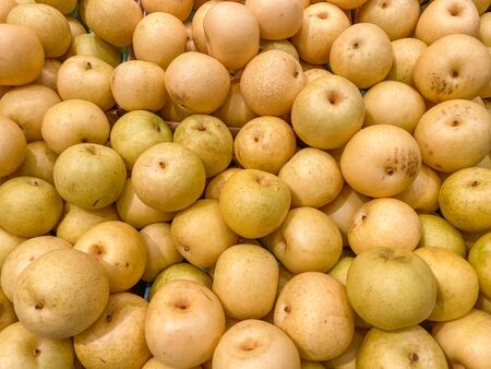 Pile of yellowish Asian fresh pears at supermarket for saleの写真素材