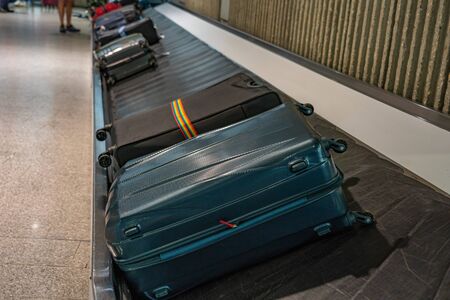 Suitcases on carousel belt at baggage claim department at airportの写真素材