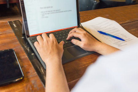 Close up photo of young man typing on laptop