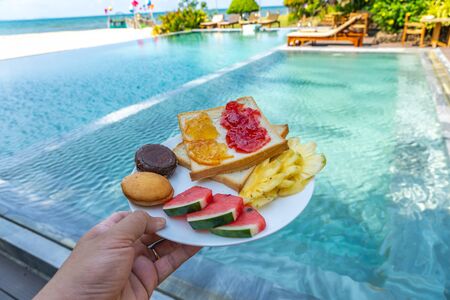 Delicious breakfast on luxury resort with swimming pool backgroundの写真素材