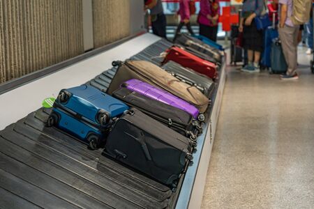 Passenger suitcases on luggage conveyor belt at the airportの写真素材