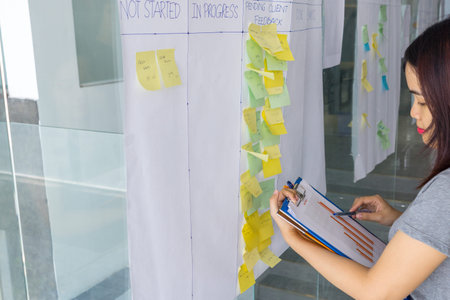 Woman cross-checking information in document with sticky note