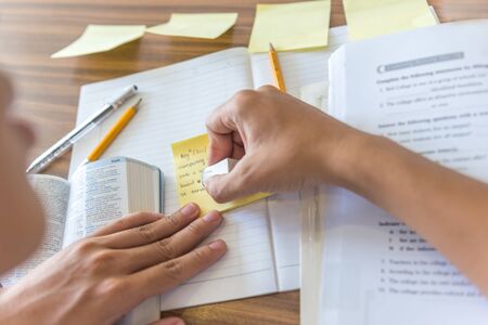 Human hand erasing some words on sticky notesの写真素材