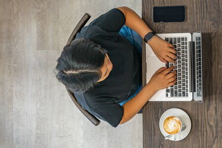 Overhead view photo of woman typing laptop at coffee tableの写真素材