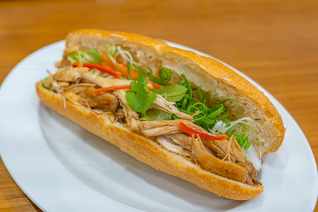 Closeup photo of chicken Banh Mi on white plate- Vietnamese cuisine