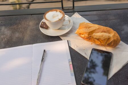 Beautiful working day with a cup of Cappuccino and breadの写真素材