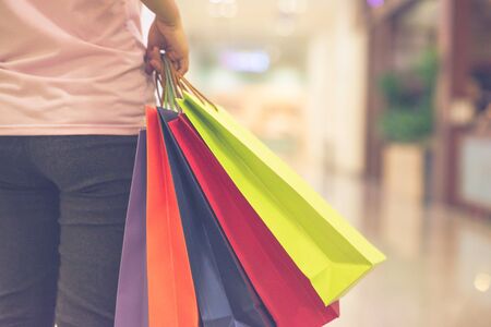 Close up photo of woman hand holding colorful shopping bagsの写真素材