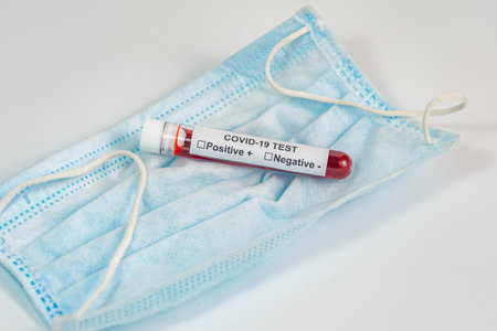 Covid-19 infection blood test sample and mask on white backgroundの写真素材