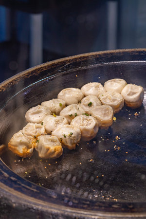 Fried dumplings on hot pan for sale at Chinese restaurantの写真素材