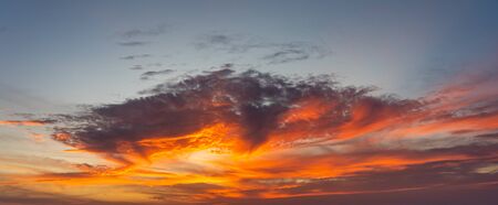 Panorama photo of dramatic sky with orange sunset and cloudsの写真素材