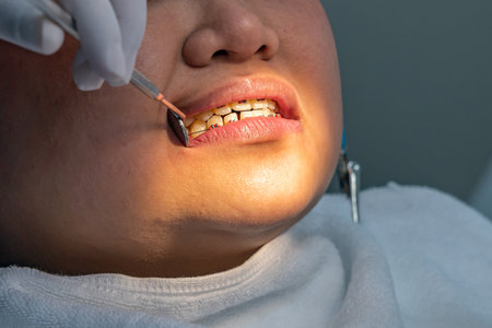 Dentist holding magifying mirror while checking teeth braces for womanの写真素材