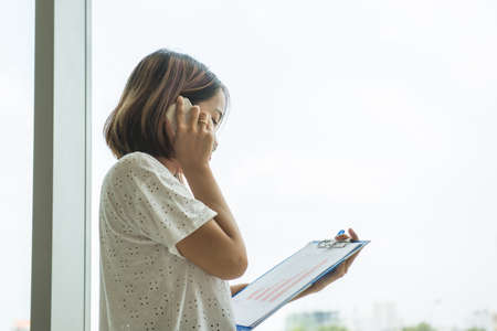 Office lady make a phone call in officeの写真素材